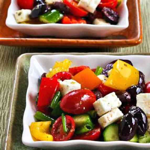 Chopped Greek Salad with Peppers shown in two stacked serving dishes