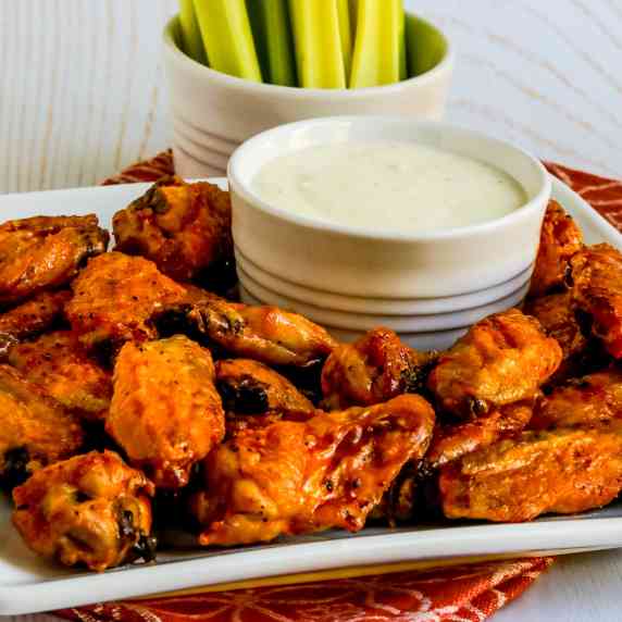 Air Fryer Buffalo Wings shown on serving platter with blue cheese dipping sauce and celery sticks.