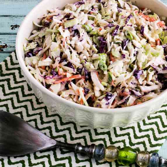 Photo of Keto Coleslaw in serving bowl with serving spoon.