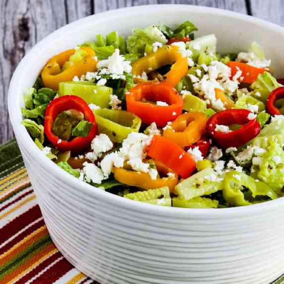 Peperoncini Salad shown in serving bowl with peperoncini and mini pepper rings on top.