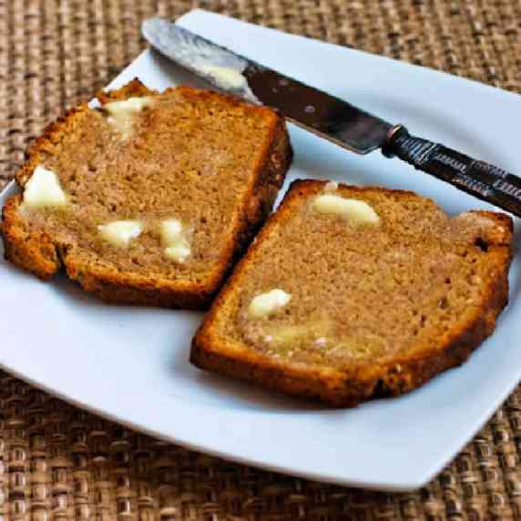 Brown Irish Soda Bread shown on square plate with butter and knife.