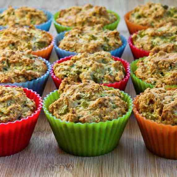 Whole wheat zucchini muffins with green chiles shown in muffin baking cups on cutting board