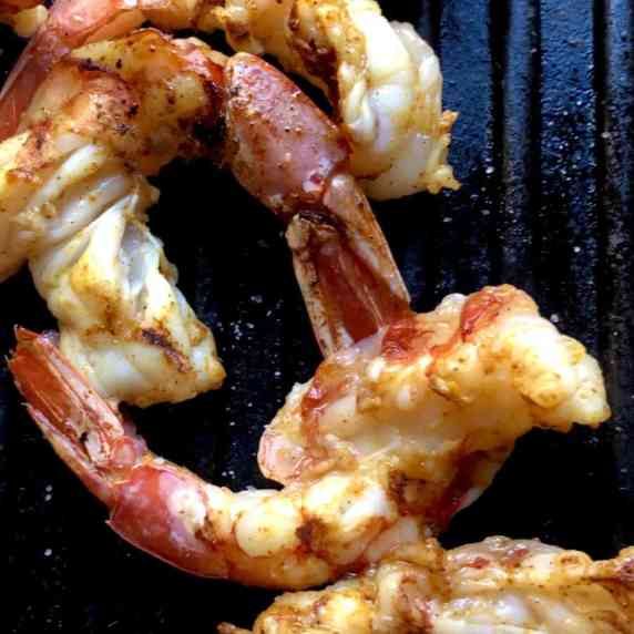 Closeup of perfectly cooked orangish-red colored opaque Argentinian Red Shrimp on the grill.