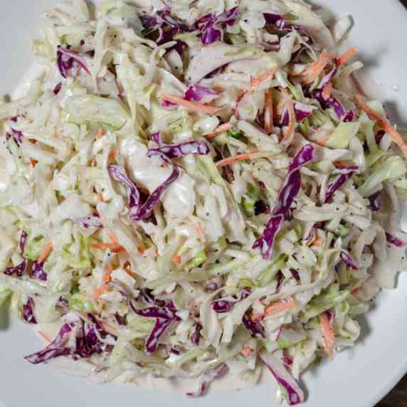 Creamy coleslaw served on a white platter.