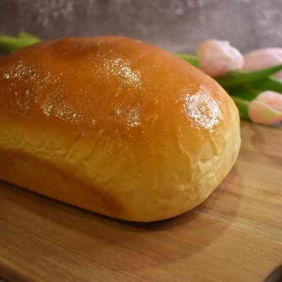 A loaf of freshly made, Amish white bread resting on a cutting board.