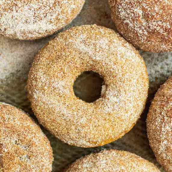 Apple cider donuts on a baking sheet.