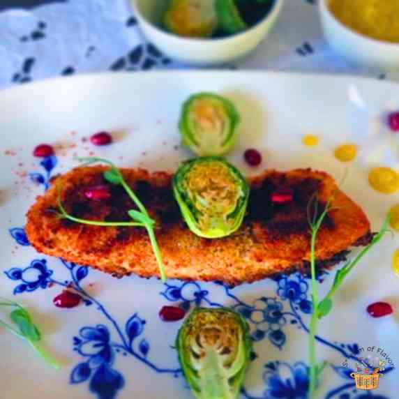 Caribbean Coconut Salmon with pika sauce with brussel sprouts on a blue and white plate