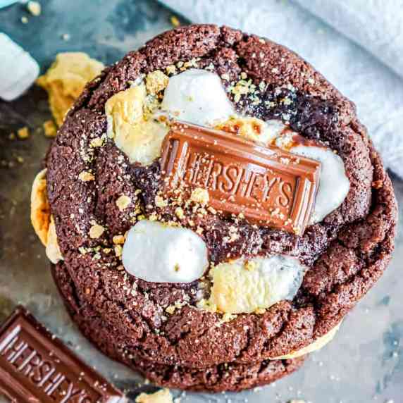 Close up of a chocolate cookie with a chocolate piece, marshmallows, and graham cracker crumbs in it