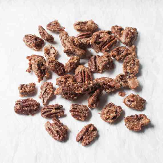 Cinnamon sugar roasted pecans on a white background.