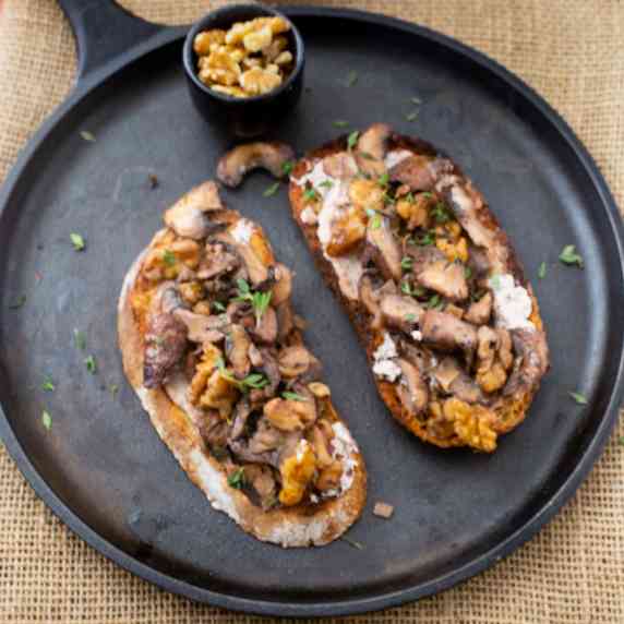 Sourdough toast topped with roasted mushroom and walnut mixture and garnished with fresh thyme. 