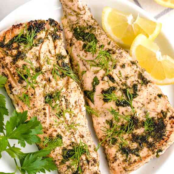 2 salmon filets covered in herbs and topped with fresh tarragon and dillweed 