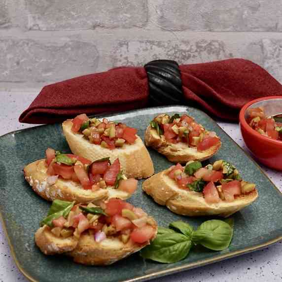 Tomato and olive bruschetta on toasted baguette.