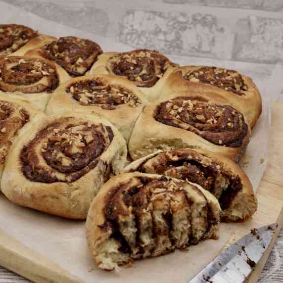 Chocolate Chelsea buns on a wooden board