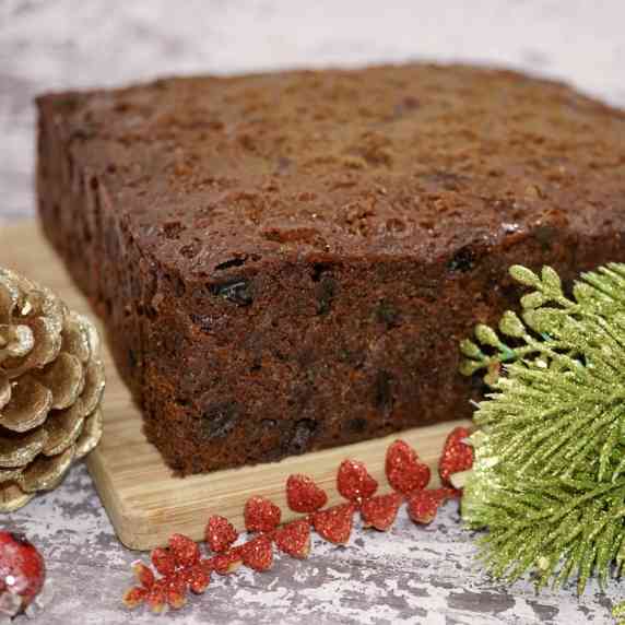 An undecorated Christmas cake on a board