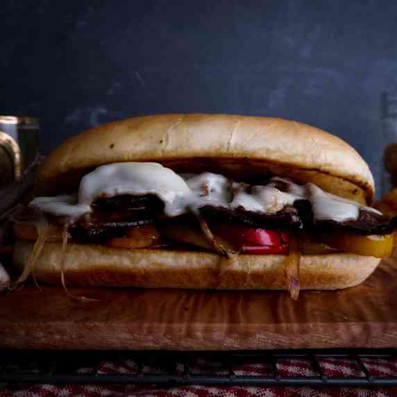 venison philly cheesesteak on wood board.