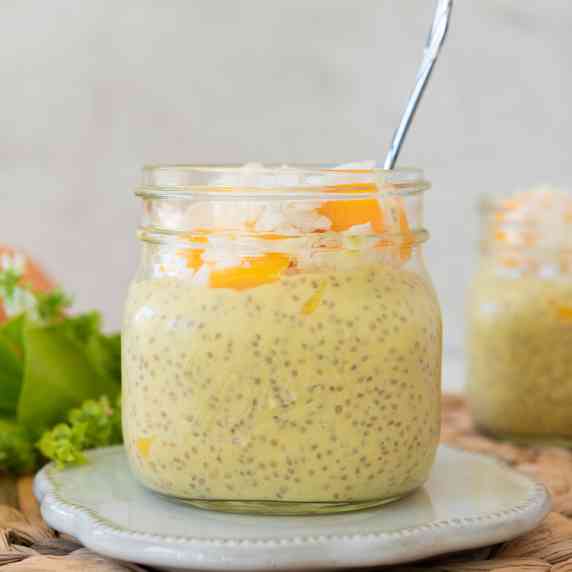 Two jars of Mango Chia Pudding with lime brances and mangoes 