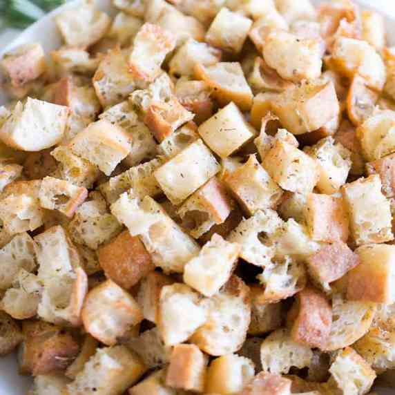 A bowl full of crispy garlic and herb croutons.
