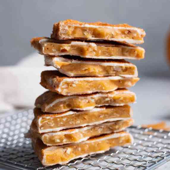 A stack of pumpkin spice toffee on a gray surface.