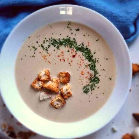 garlic soup with croutons in a white bowl.