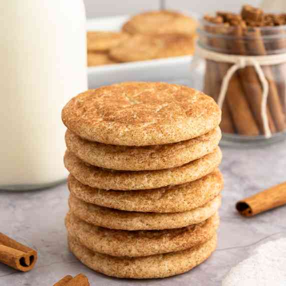 Stack of gluten-free snickerdoodle cookies with milk and cinnamon sticks