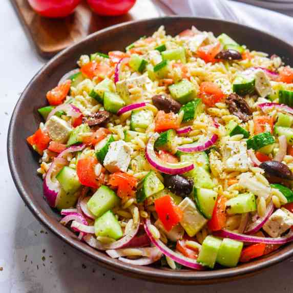 Greek orzo salad in a bowl garnished with dry oregano