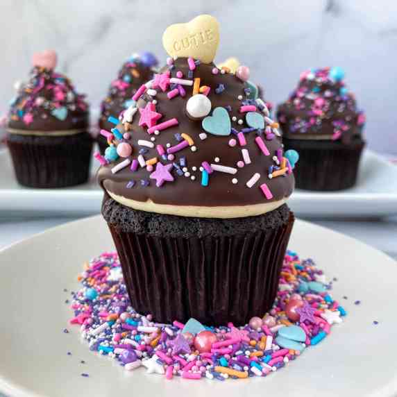 High Hat Cupcake on a white plate with Valentine's Day sprinkles.
