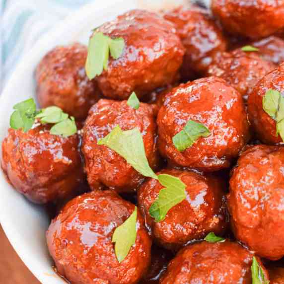 cranberry bourbon cocktail meatballs in a white bowl with parsley