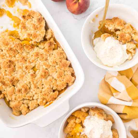 two servings of peaches and cream cobbler in white bowls