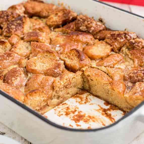 Close up of the inside of a dish with krispy kreme bread pudding and a slice missing.