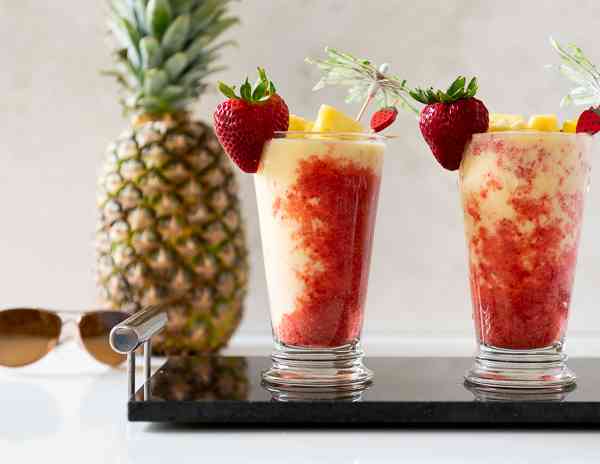 Pina Colada and Strawberry Puree in a Tall Glass with a Pineapple and Sunglasses