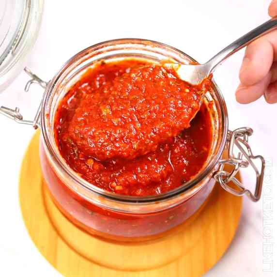 Keto tomato sauce spooned out of a mason jar.