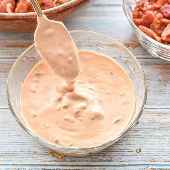 low fodmap burger sauce drizzling from a spoon into a bowl of sauce