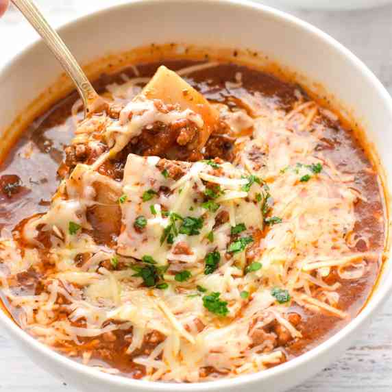 a spoon scooping up low fodmap low carb lasagna soup in a white bowl