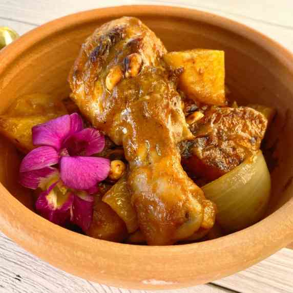 Thai massaman chicken curry in a clay bowl.