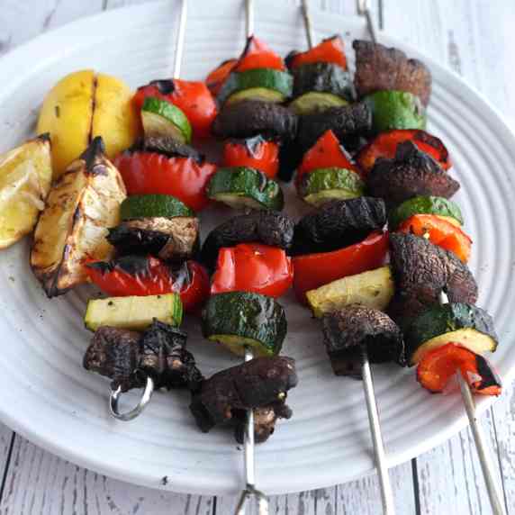 Skewers of grilled vegetables on a plate.