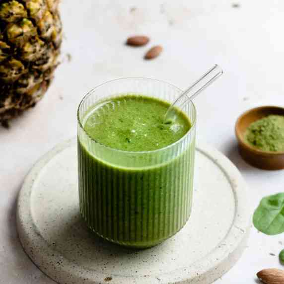 Pineapple moringa smoothie in an aesthetic cup with straw