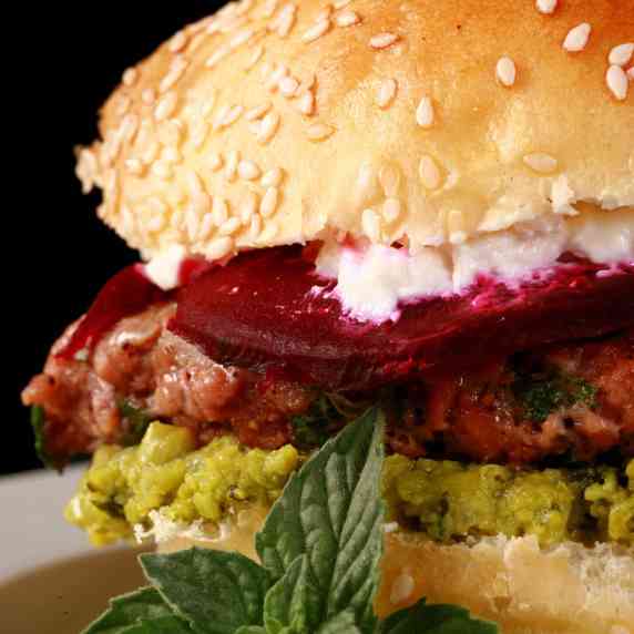 A moroccan spice beyond burger with beet slices, pea hummus, and goat cheese.