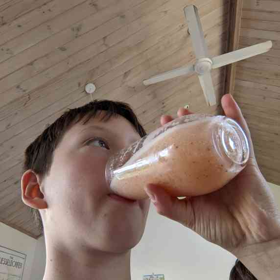 a kid drinking the smoothie.
