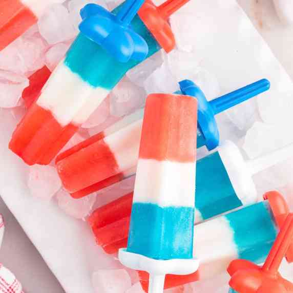 This patriotic bomb pops recipe is made with only 4 ingredients and a popsicle mold, just in time fo