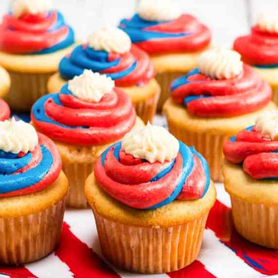 An up close view of a cupcake frosted with red white and blue frosting.