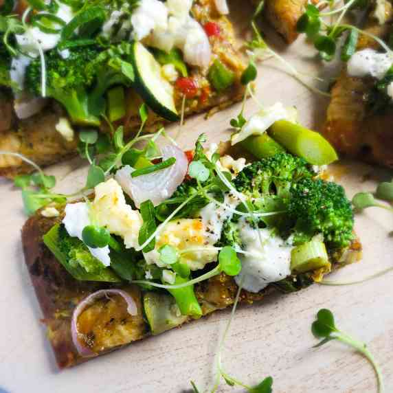 Crispy golden flatbread topped with creamy white cheese and gorgeous green veggies.