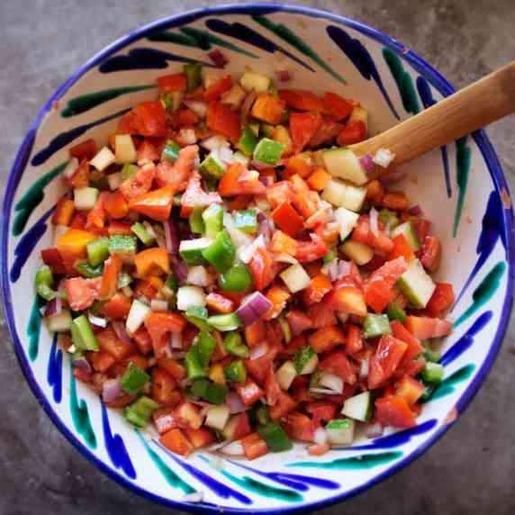 a large colorful bowl of Pipirrana salad sits waiting to be served. 