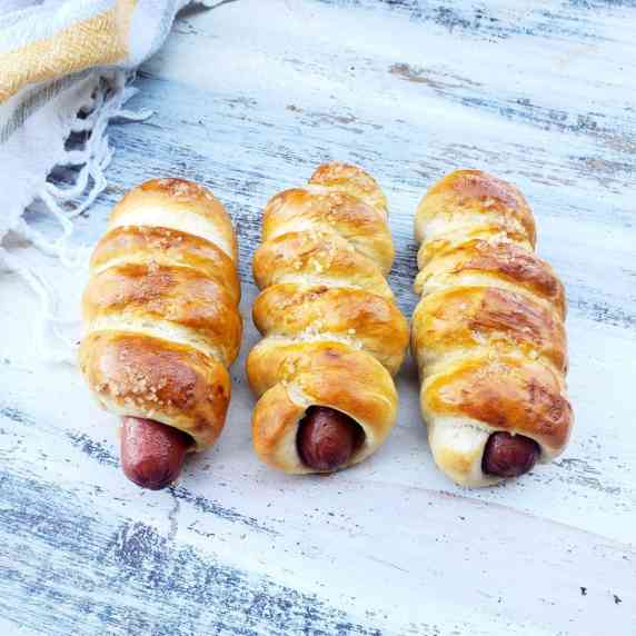 Hot dogs wrapped with soft pretzel with salt.