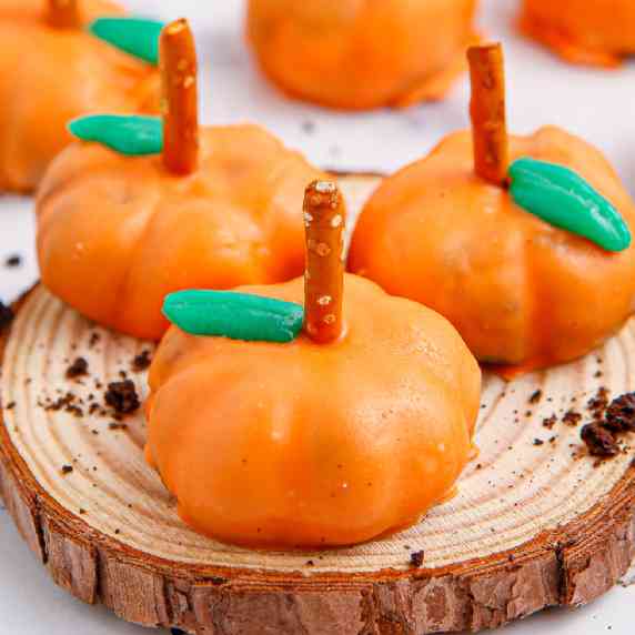 Square view of pumpkin oreo balls from the side lined up on a platter.