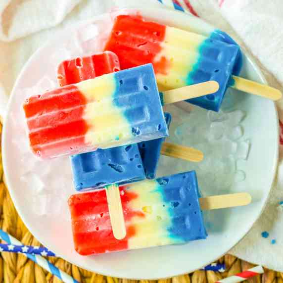 Red white and blue popsicles piled on a plate from overhead.