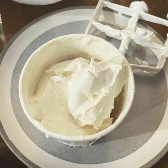 a photo of re-churned vanilla ice cream in its container and the beater from the ice cream machine