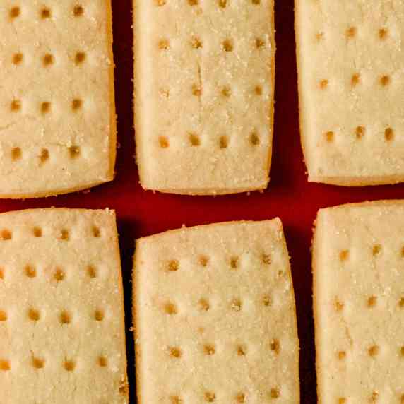 Shortbread cookies laying flat on a red background