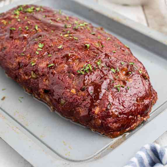 A smoked meatloaf on a baking sheet.