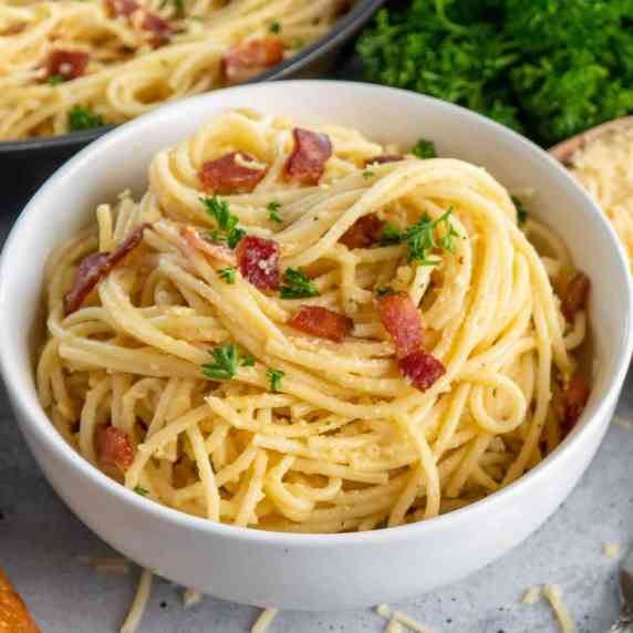 Spaghetti carbonara in a white bowl.