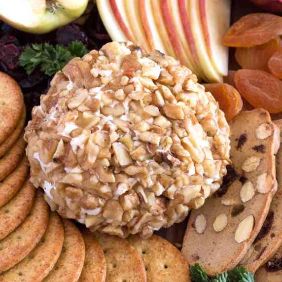 Cheeseball on platter surrounded by crackers.